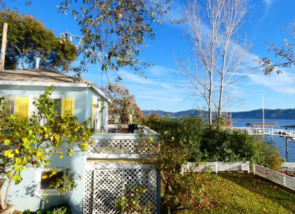 Blue cottage with yellow shutters by Clear Lake and garden with lake view