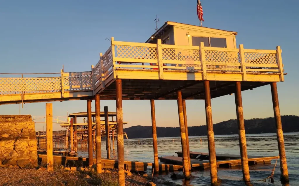Elevated house on wooden pier at Clear Lake during golden hour