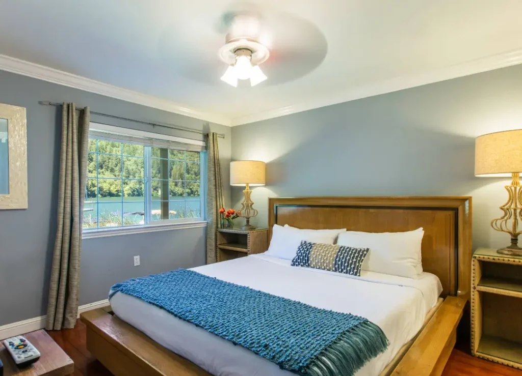 Cozy bedroom with a lake view window, king bed, and blue accent throw