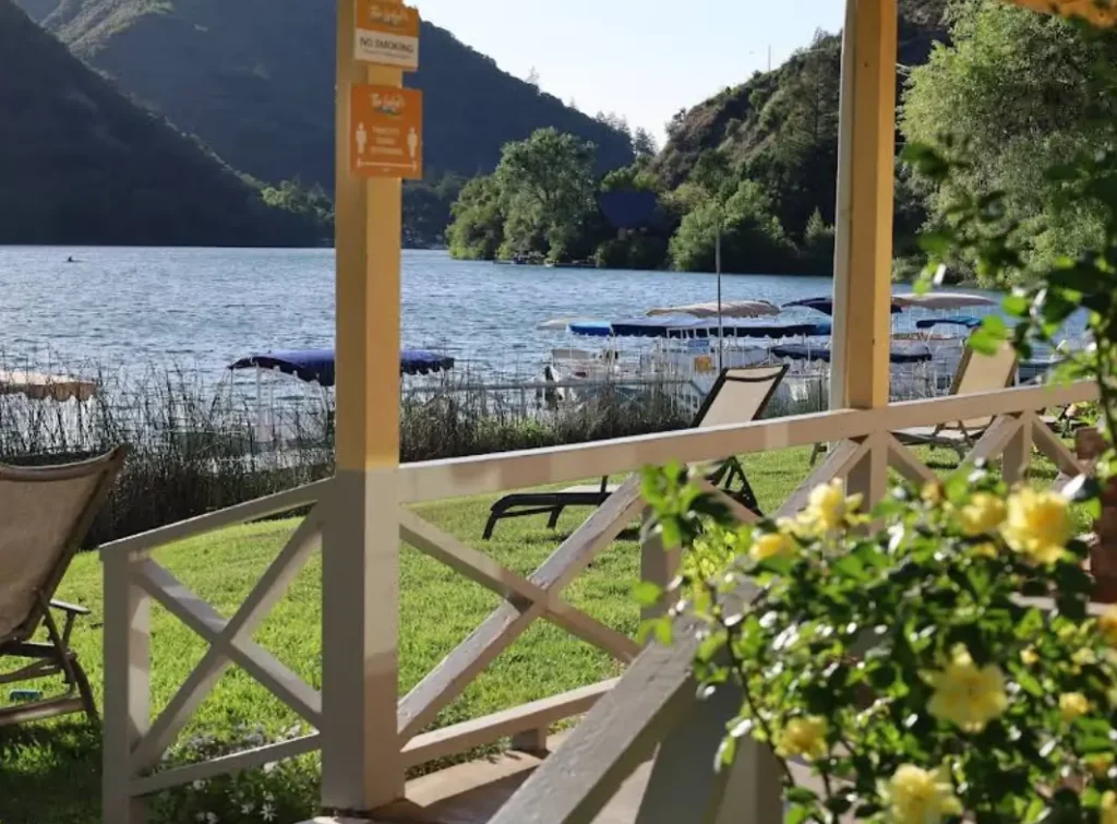 Veranda view with lounge chairs facing a calm lake and forested hills
