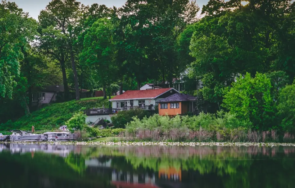 Small cabin and boats along a forested lakeshore