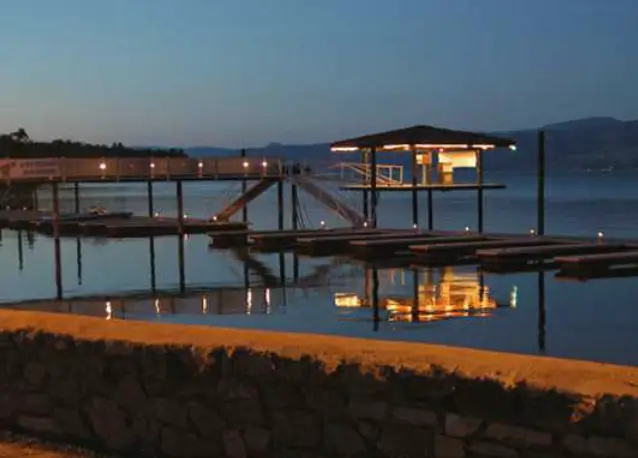 Dock with soft lighting reflecting on lake water at dusk